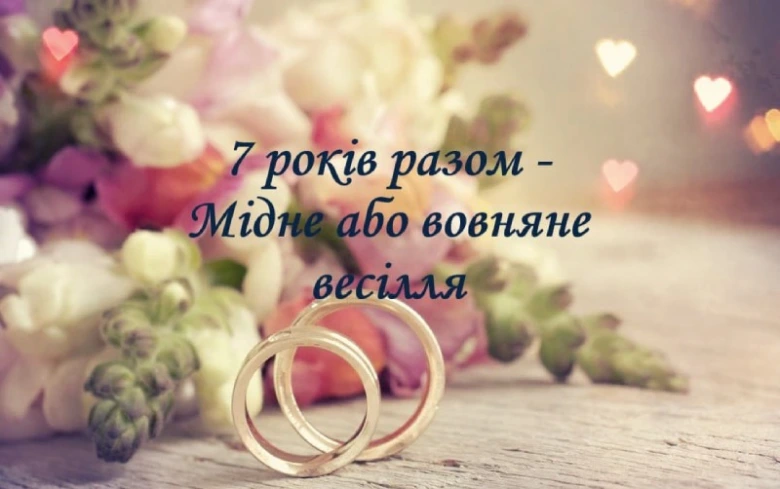 Два золоті кільця на квітах з привітанням до річниці весілля.