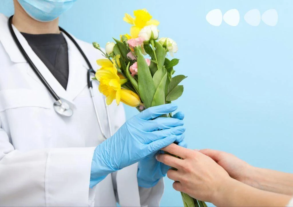 Лікар передає квіти пацієнту на знак вдячності.