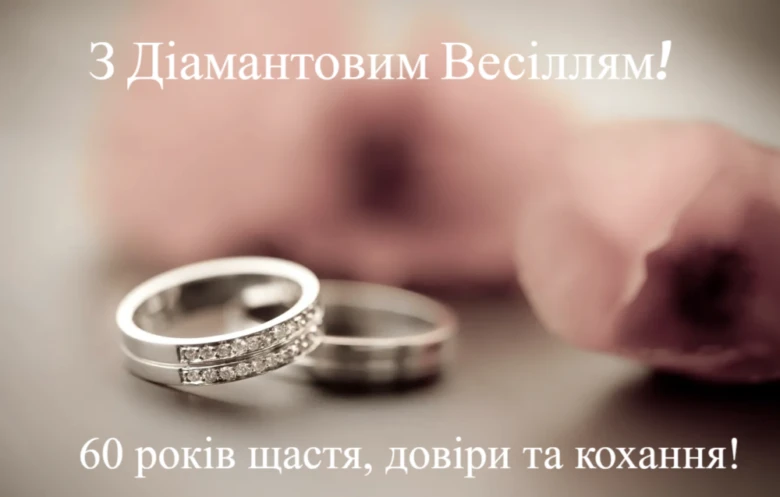 Два обручальні кільця з діамантами та троянда на фоні.